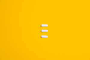 white three oval capsule on yellow canvas