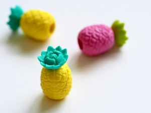three plastic pineapple figures on white surface